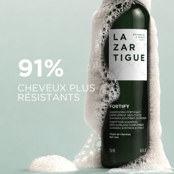Lazartigue – Shampoing Fortify ( Shampoing Fortifiant Antichute ), bouteille de shampoing vert foncé avec de la mousse blanche sur le côté