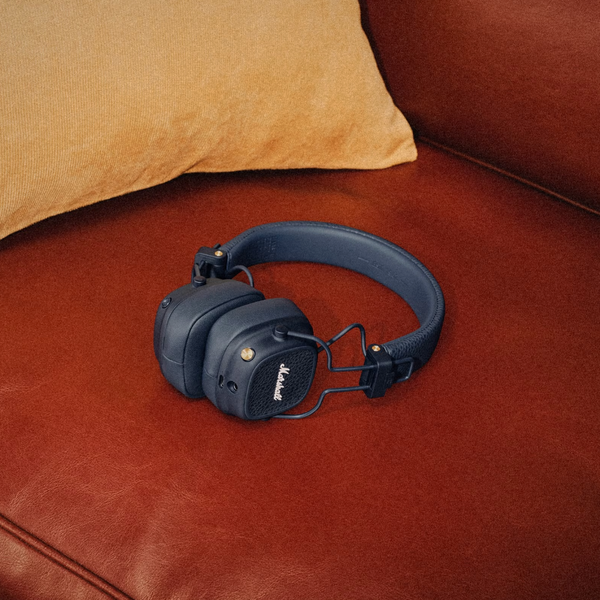 Marshall – Major V - Casque Sans Fil - Midnight Blue, casque audio noir posé sur un canapé en cuir marron
