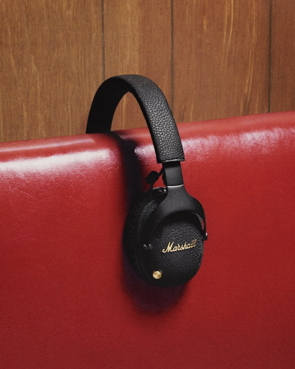 Marshall – Monitor III ANC - Casque Sans Fil - Noir, casque audio noir posé sur un dossier de canapé rouge